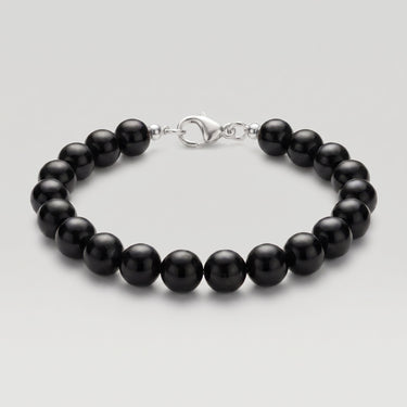 A studio product shot of a women's 8mm natural gloss onyx bead bracelet with a sterling silver lobster clasp on a light gray background.