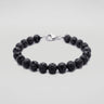 A studio product shot of a women's 8mm natural black lava bead bracelet with a sterling silver lobster clasp.