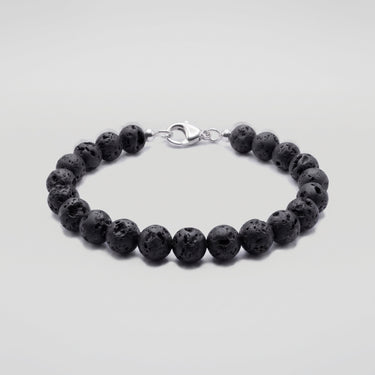 A studio product shot of a women's 8mm natural black lava bead bracelet with a sterling silver lobster clasp.