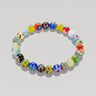 A studio product shot of a 8mm handmade Millefiori glass bead stretchy  bracelet featuring a 14K gold-filled accent bead, showcasing vibrant multi-colored floral patterns.