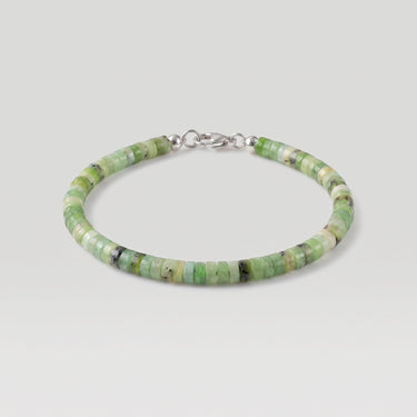 A studio product shot of a woman's 4mm African green chrysoprase heishi bead bracelet featuring a genuine sterling silver lobster clasp, highlighting the disk shape and matte natural stone texture.