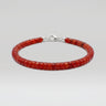 A studio product shot of a women's 4mm natural red agate heishi bead bracelet with a sterling silver clasp, highlighting the vibrant crimson tones and uniform disk-shaped stones.