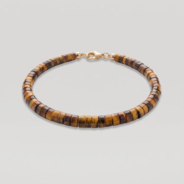 A studio product shot of a women's 4mm natural tiger's eye heishi bead bracelet with a 14K gold-filled clasp, highlighting the rich golden-brown chatoyancy and disk shape.