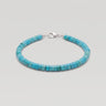 A studio product shot of a 4mm turquoise heishi bead bracelet with a sterling silver lobster clasp, showcasing the uniform disk shape and natural semi-precious stone texture.
