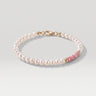 A studio product shot of a women's 4mm natural pearl and rhodonite bead bracelet with a 14K gold-filled clasp, featuring high-luster pearls accented by soft pink gemstone tones.