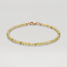 A studio product shot of a women's delicate 2mm natural faceted peridot cube bead bracelet with a 14K gold-filled clasp.