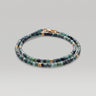 A studio product shot of a women's 3mm natural faceted tourmaline cube wrap bracelet featuring 14K gold-filled bead accents, highlighting the multi-tonal green gemstones and elegant layered design on a white background.