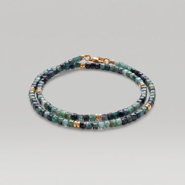 A studio product shot of a women's 3mm natural faceted tourmaline cube wrap bracelet featuring 14K gold-filled bead accents, highlighting the multi-tonal green gemstones and elegant layered design on a white background.