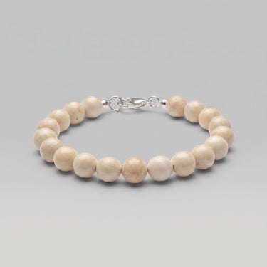 A studio product shot of a women's 8mm natural fossil jasper bead bracelet with a sterling silver lobster clasp, highlighting the organic earth-toned patterns.