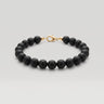 A studio product shot of a women's 8mm natural matte onyx bead bracelet with a 14K gold-filled lobster clasp.