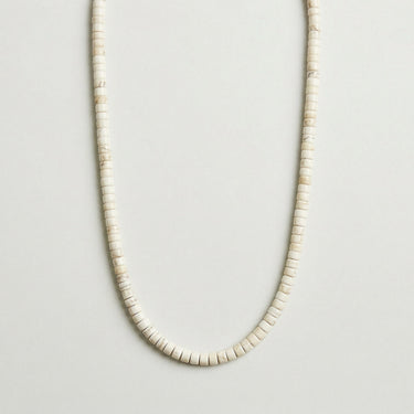 A professional studio hero shot of the women's 4x2mm white turquoise heishi necklace arranged in a U-shape against a neutral background, highlighting the uniform disc shape and crisp white color.
