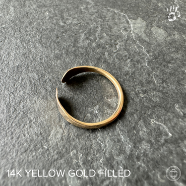 yellow gold filled toe ring on a dark background
