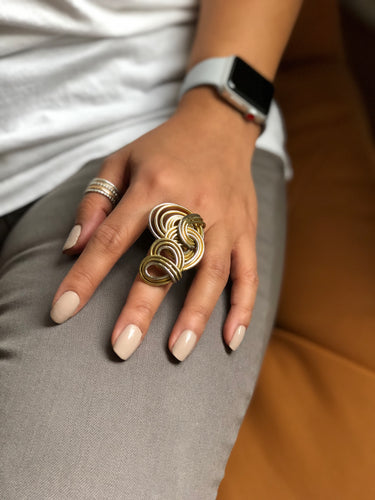 A person wearing the Barrel Wave ring, paired with a stacking set on another finger, demonstrating how the mixed metals can be styled together.