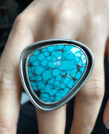 Top-down view showing the 28mm x 42mm turquoise cabochon with natural matrix patterns, highlighting the double sterling silver setting and textured metalwork.