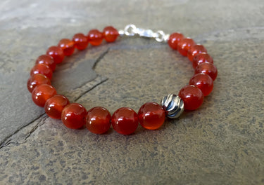 Carnelian 8mm beads bracelet with sterling silver lobster clasp. Has one accent sterling silver wave bead.
