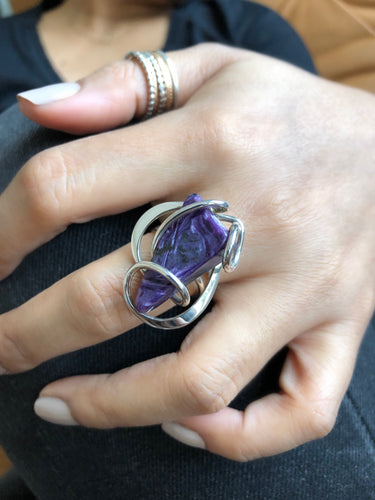 A handpicked purple Charoite stone secured in an intricate sterling silver wire-wrapped setting designed to look like waves.