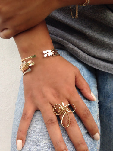Model wearing a sculptural 14k gold-filled statement ring featuring an abstract wire-formed wave design