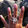model wearing a sculptural sterling silver statement ring featuring an abstract wire-formed wave design
