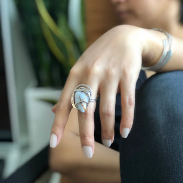 Model wearing Rainbow Moonstone Wave Ring in sterling silver wire-wrapped setting