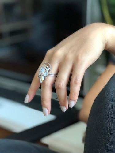 Side view on model of Rainbow Moonstone Wave Ring showing sculptural sterling silver wire wrap