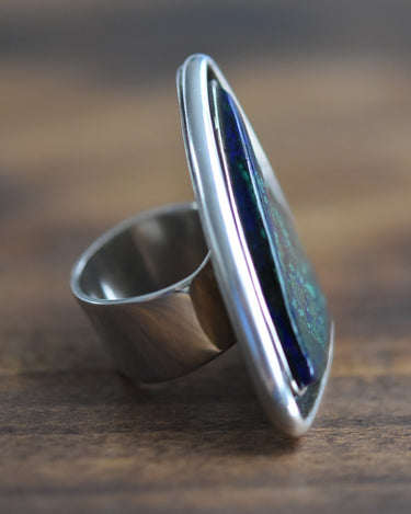 Side profile of bold sterling silver statement ring with gemstone center