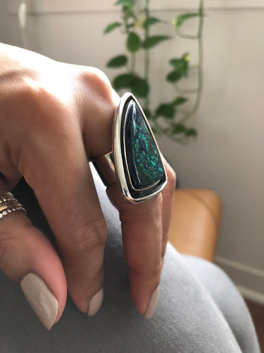 Large chrysocolla ring with handcrafted silver design shown from angled view on model's hand