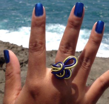 Dark blue and light green color anodized aluminum wire wrap ring. 
